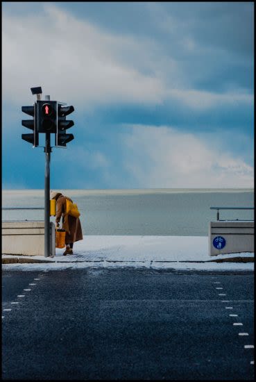 person at traffic lights with blue skies