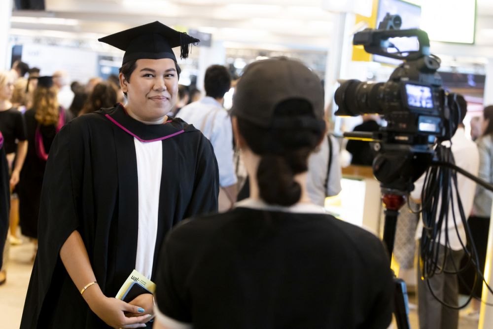 Graduate being recorded and speaking into a camera