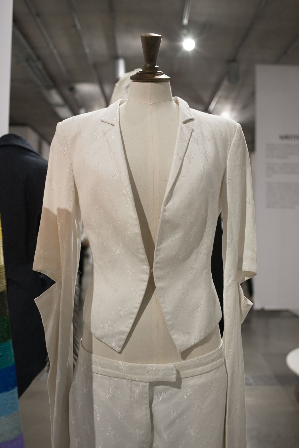 Detail of white suit and trousers on mannequin