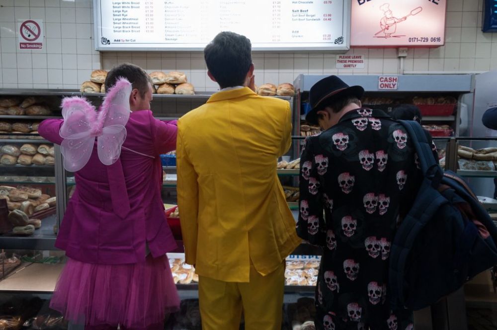three people in fancy dress at a food counter