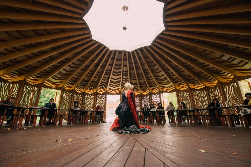 View of the model's back with onlooking students
