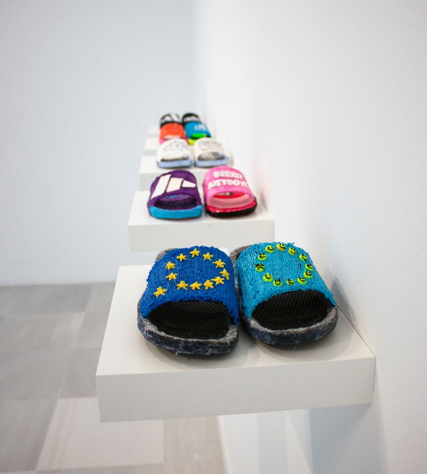 Handmade slippers are on display. The first pair have the EU symbol on it