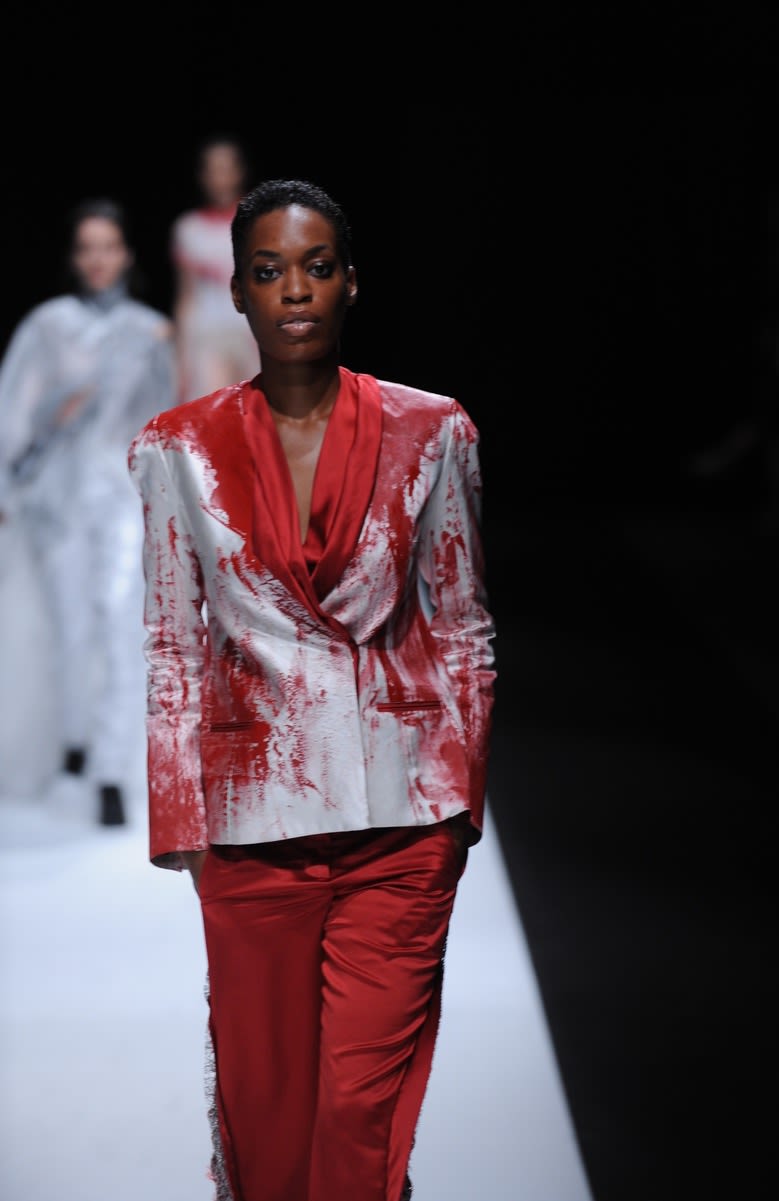 Female model wearing red and silver suit designed by Kang An