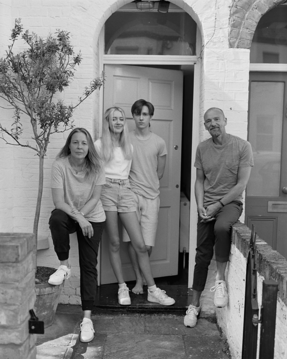 black and white photo of family standing on the doorstep of their home