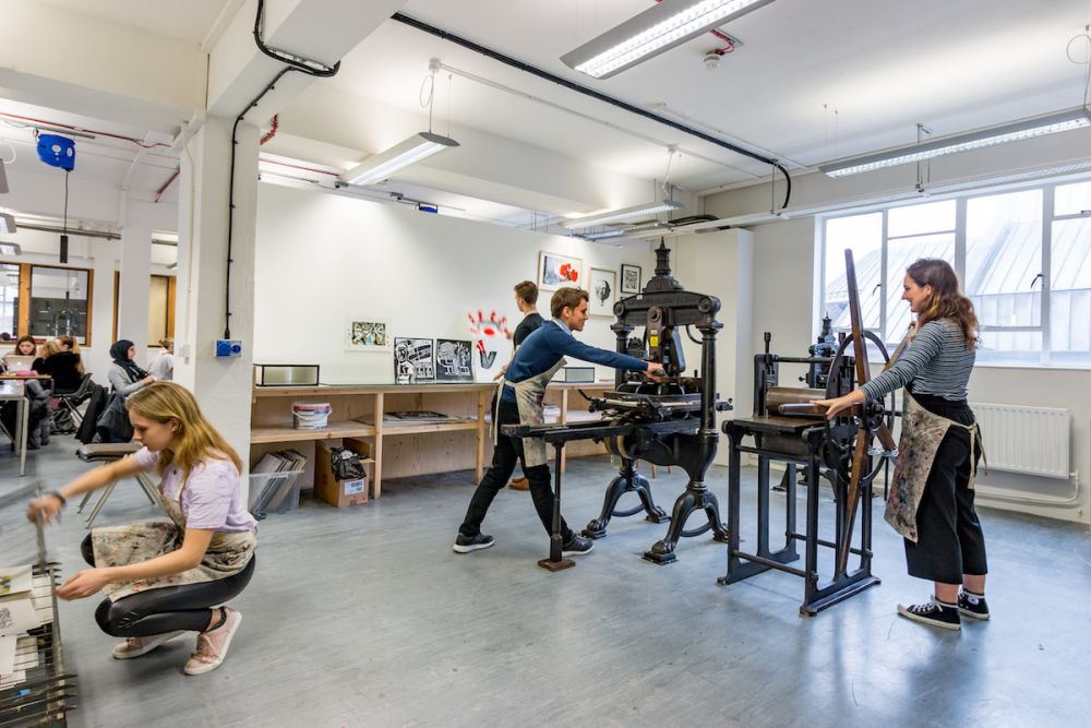 Students using a printing press  inside Central Saint Martins' Archway campus