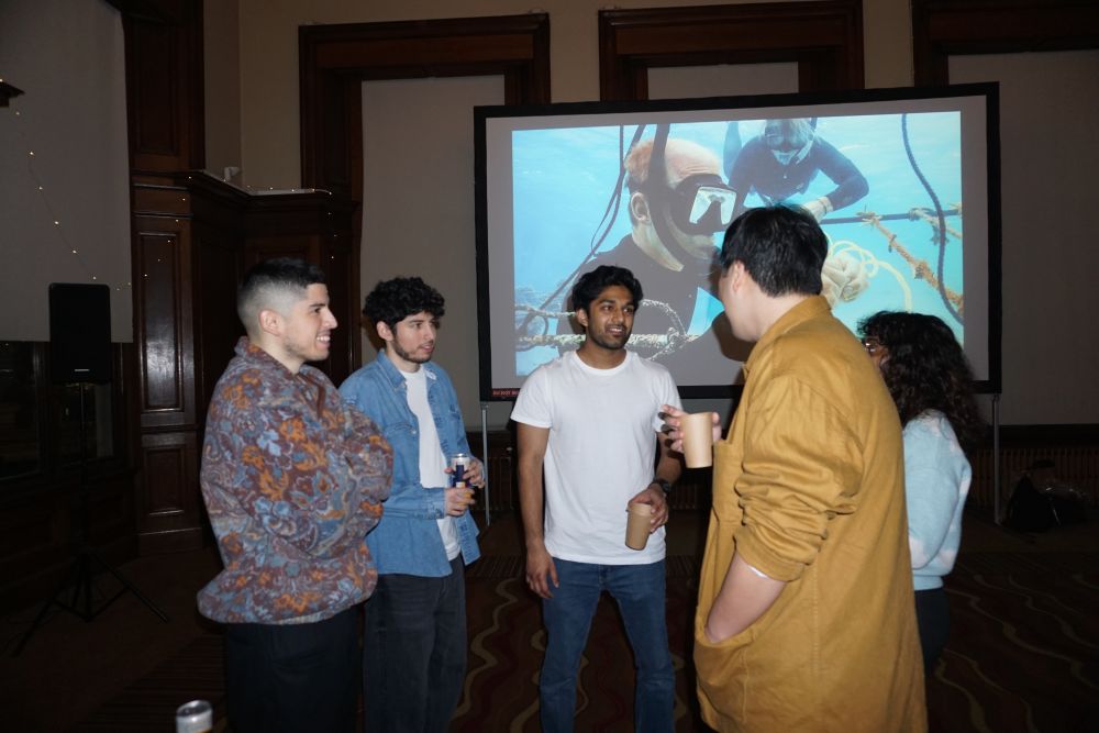 a group of students standing and talking at an event