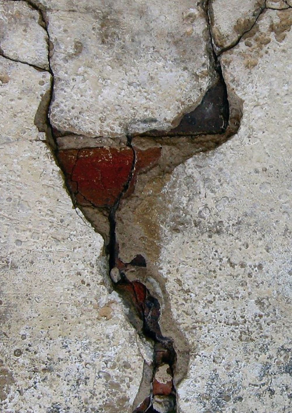 Close-up of red detailing in a crack in a concrete wall