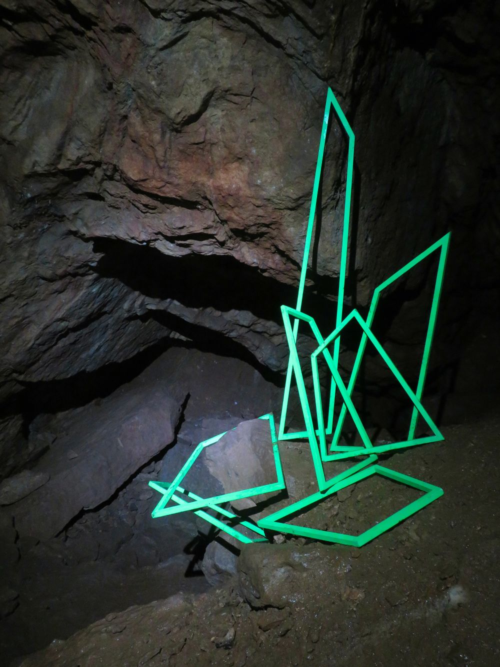 Green linear sculptures in a cave