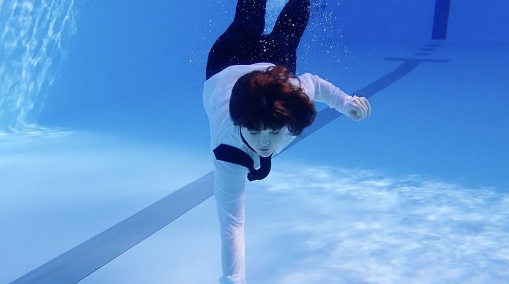 A person wearing a suit swimming underwater
