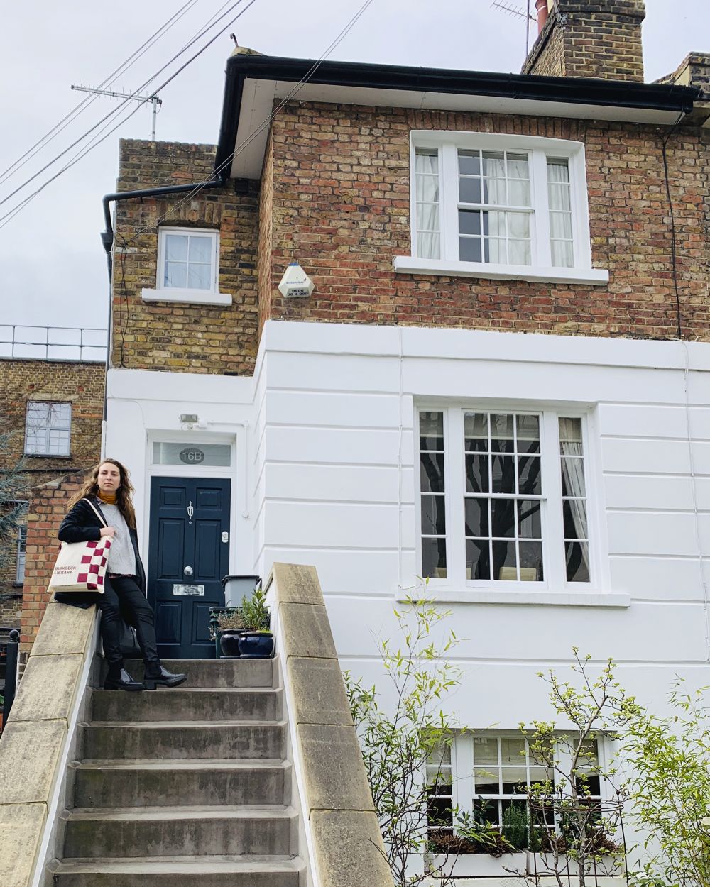 girl standing on steps to house with bags