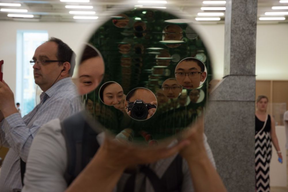 people looking into a mirror with their camera
