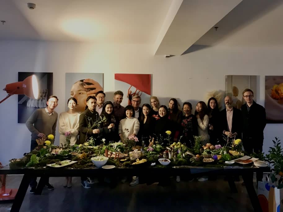 Group photo with a table of food in front