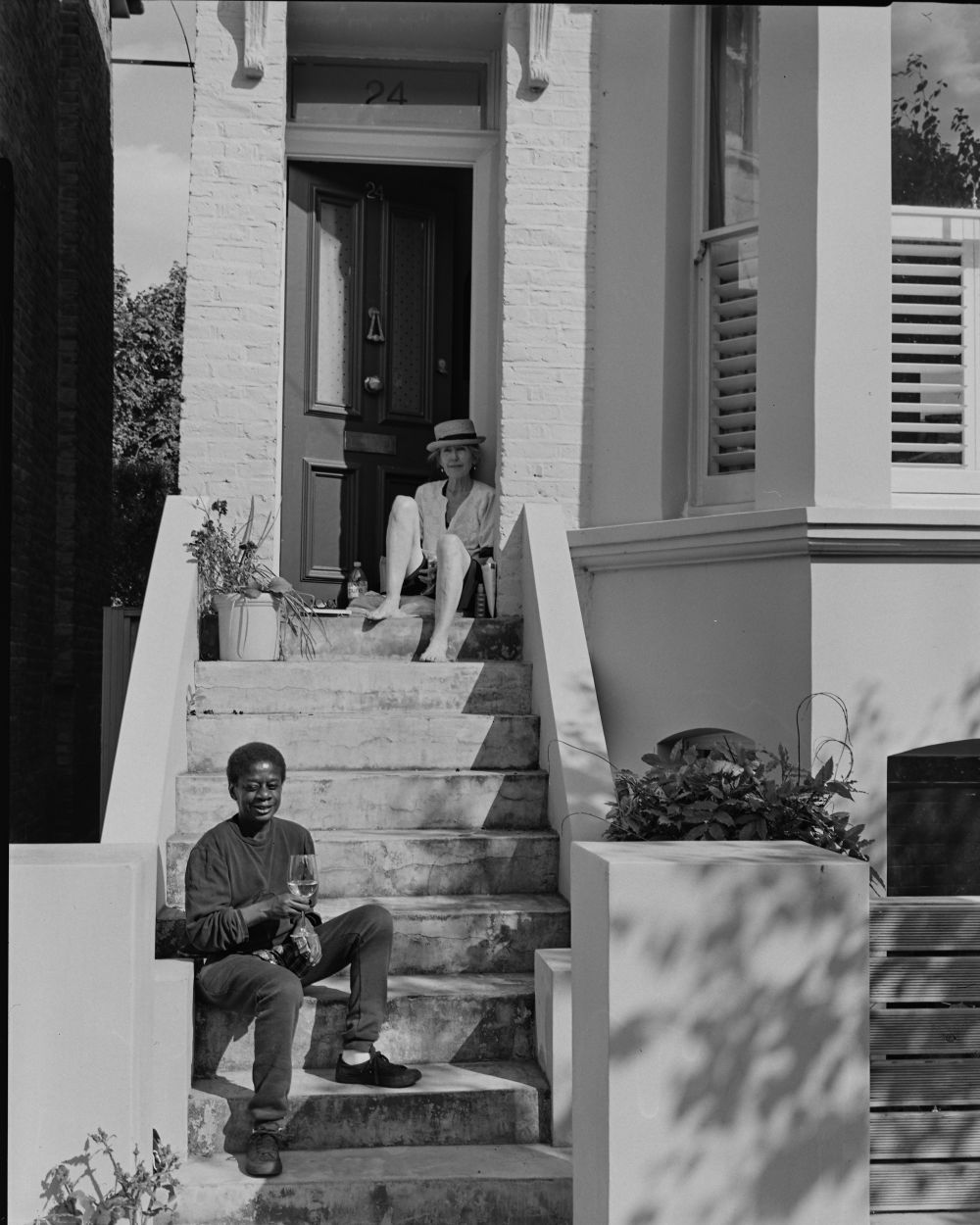 black and white photo of family standing on the doorstep of their home