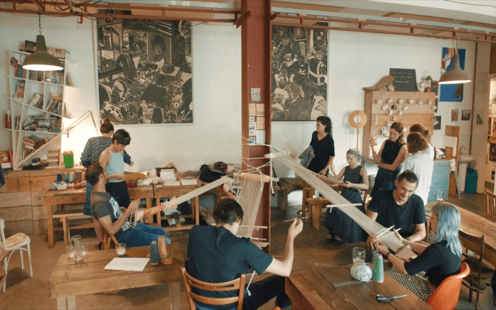Busy workspace full of people learning to weave