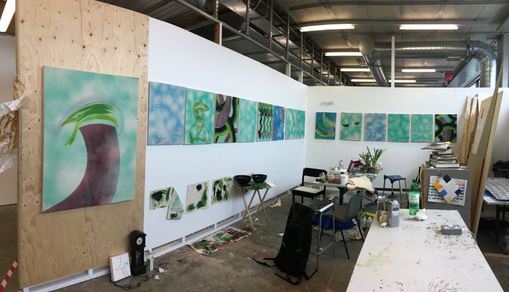 Nineteen paintings arranged in studio