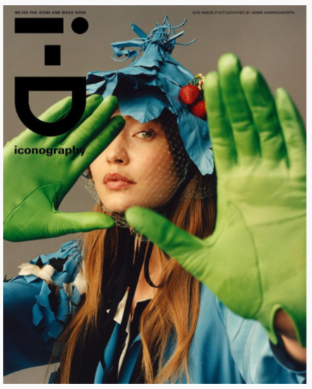 an ID magazine cover with a woman with hands out toward the camera wearing green gloves