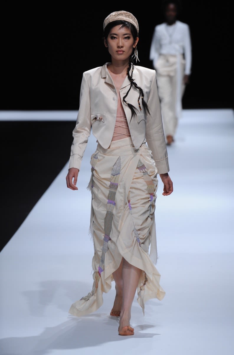 Female model wearing a multi-piece dress and jacket designed by So Jung Kim