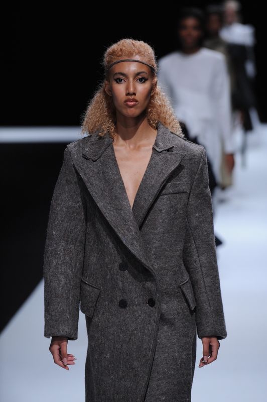 Female model with long, oversized grey woolen blazer.