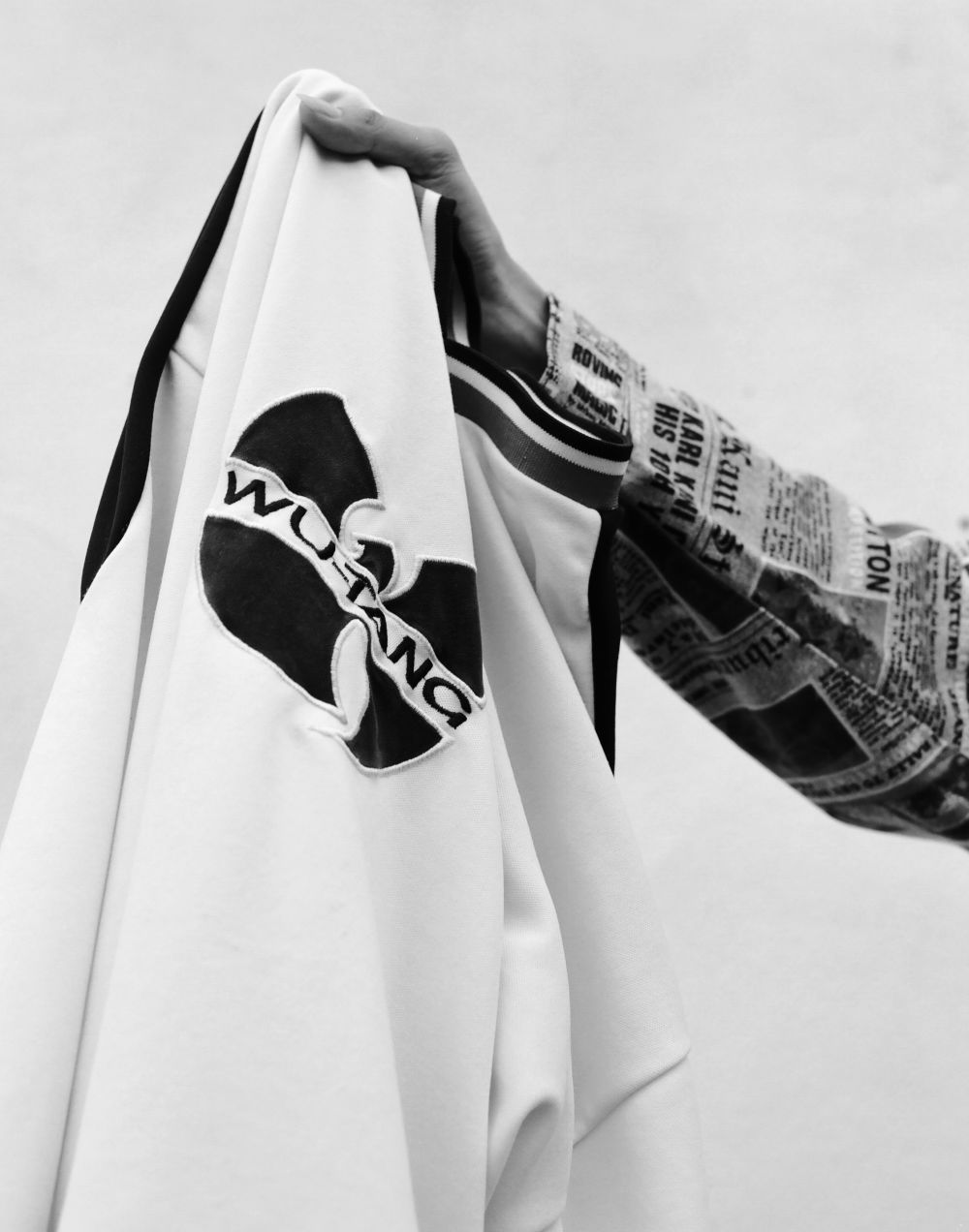 Photograph of a sweatshirt with a Wu-Tang logo being held up 