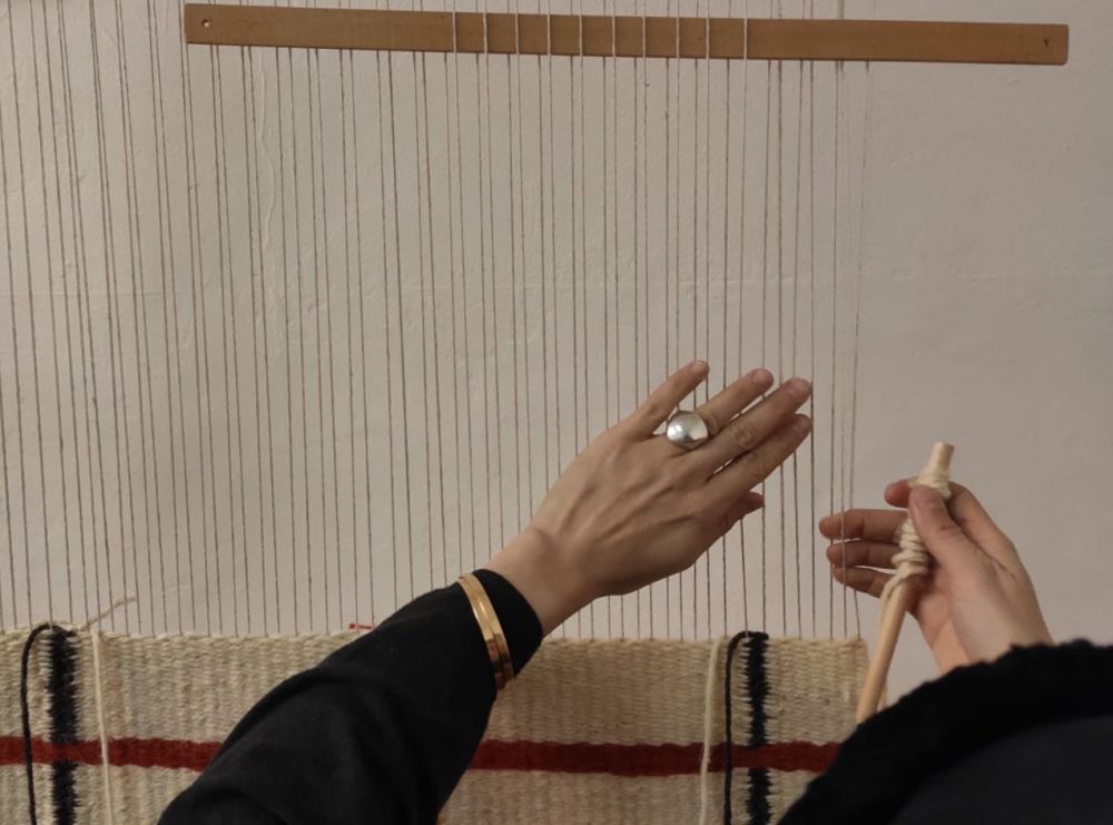 hands weaving on a loom