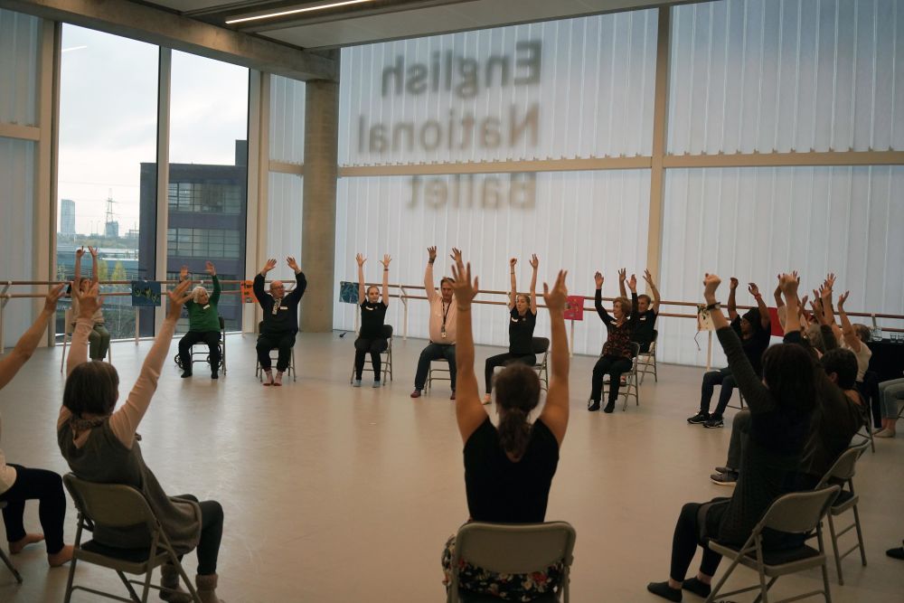 People sitting in circle with hands in the air