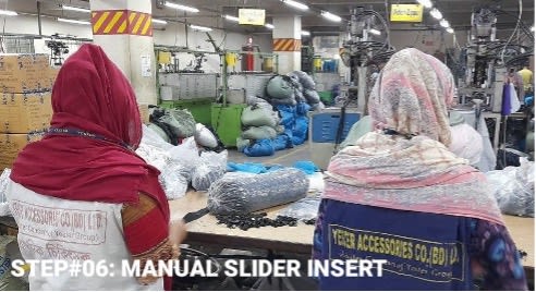 Two factory workers in headscarves with their backs to the camera shot in a factory with production room visible. They are working with garment fastenings at a table. Text states Step 06: Manual Slider insert