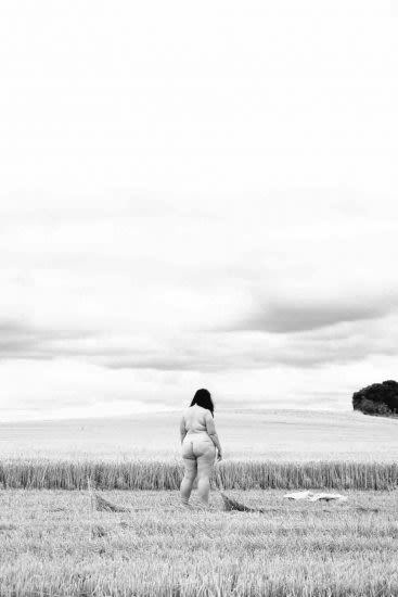 nude woman standing in field