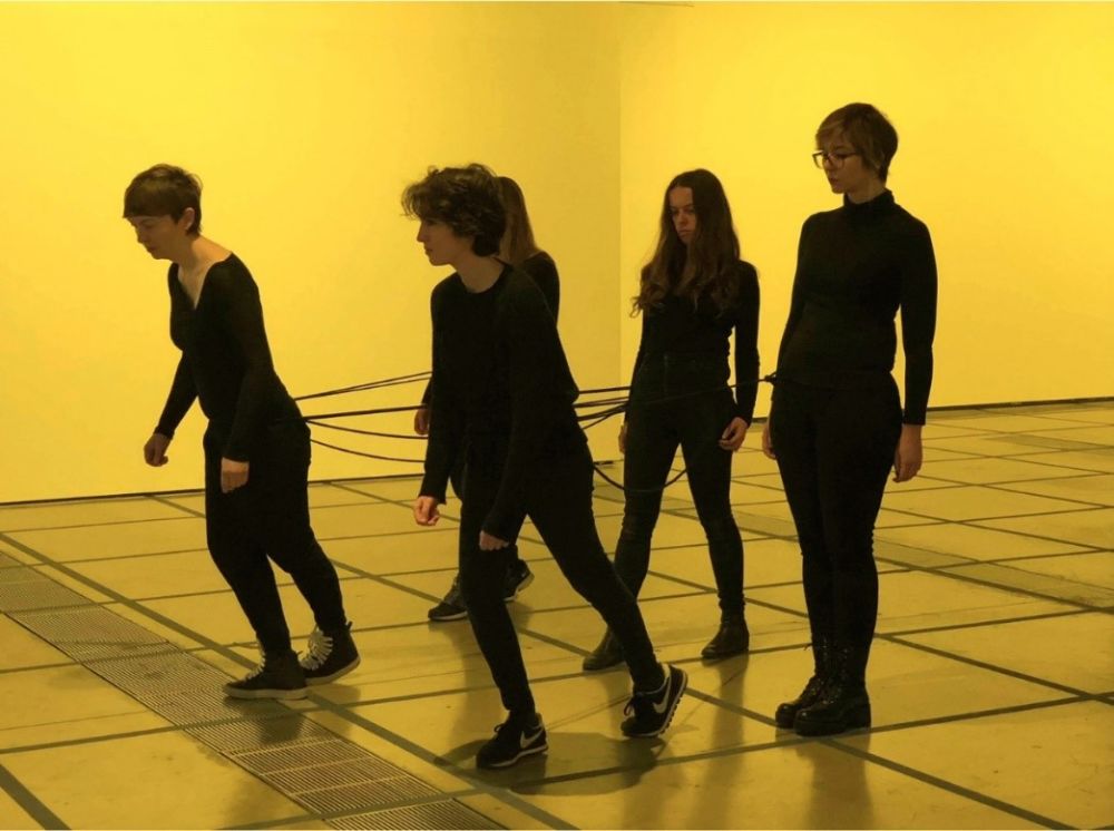 performance photo, women dressed in black in a yellow room