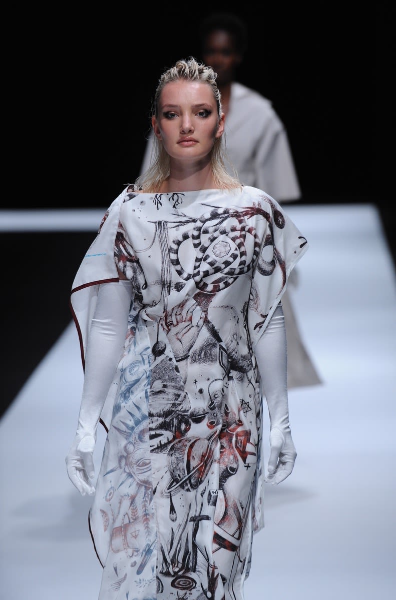 Female model wearing long white and red embroided dress designed by Xinyi Zheng