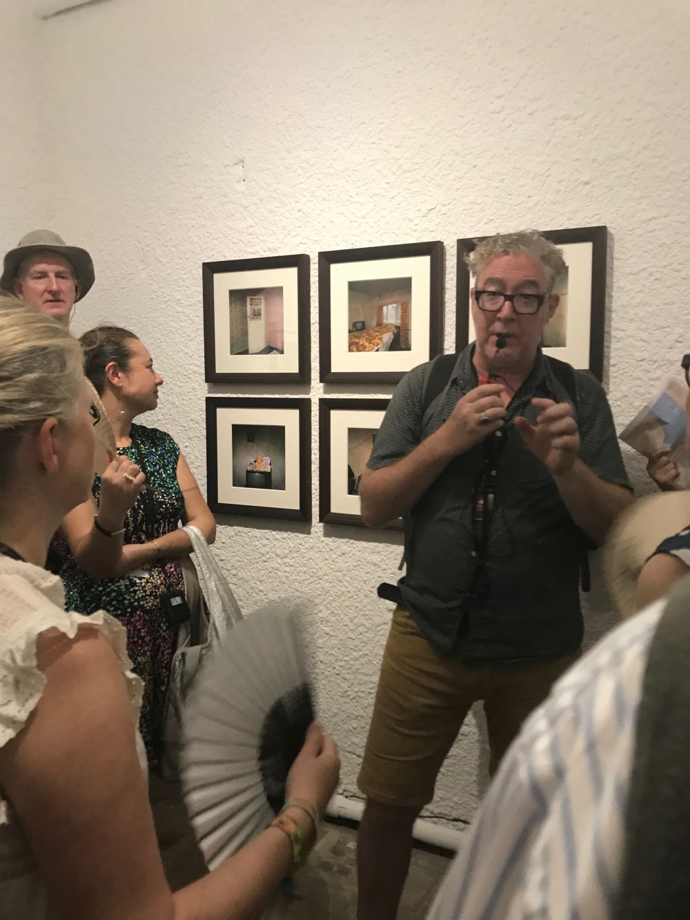 Image of david stewart talking about the photographs behind him in the gallery