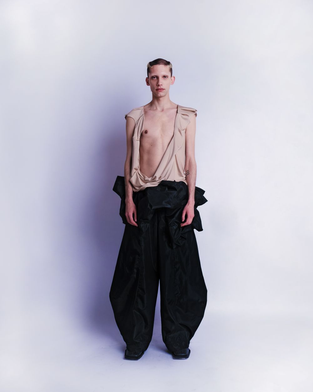 Male model with loose open top and black baggy trousers.