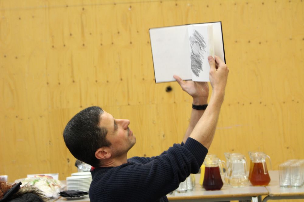 One participant presents their sketches to the class by holding up their sketchbook