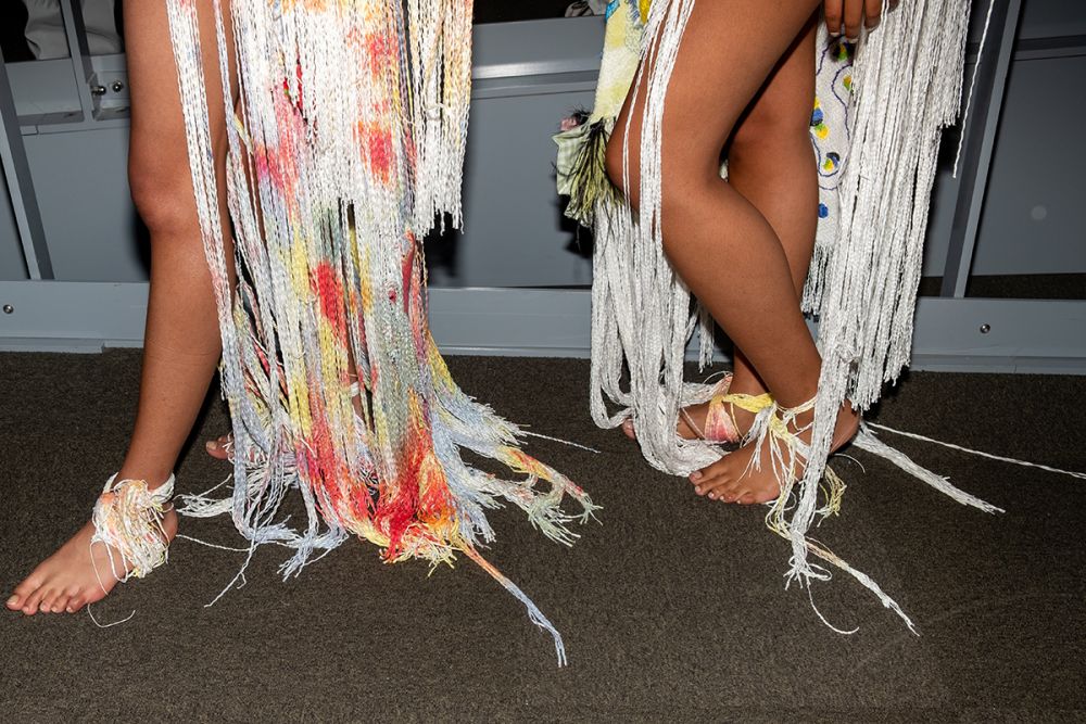 Closeup of models skirts which are made up of multicoloured tassels