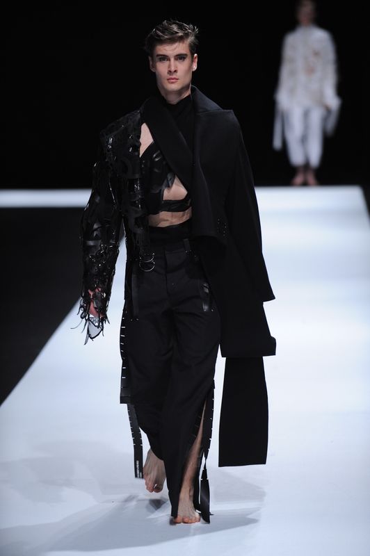 Brunette male model with black stitched clothing