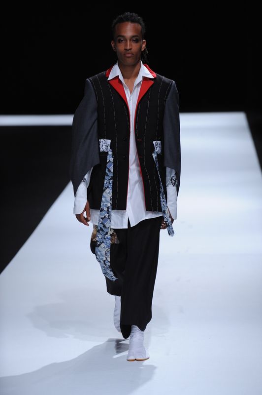 Male model with black patchwork blazer with red lapels