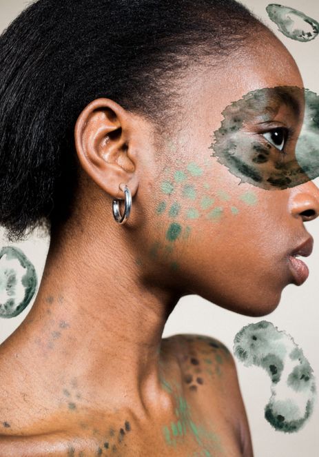 Close up of black female model with green patterned makeup