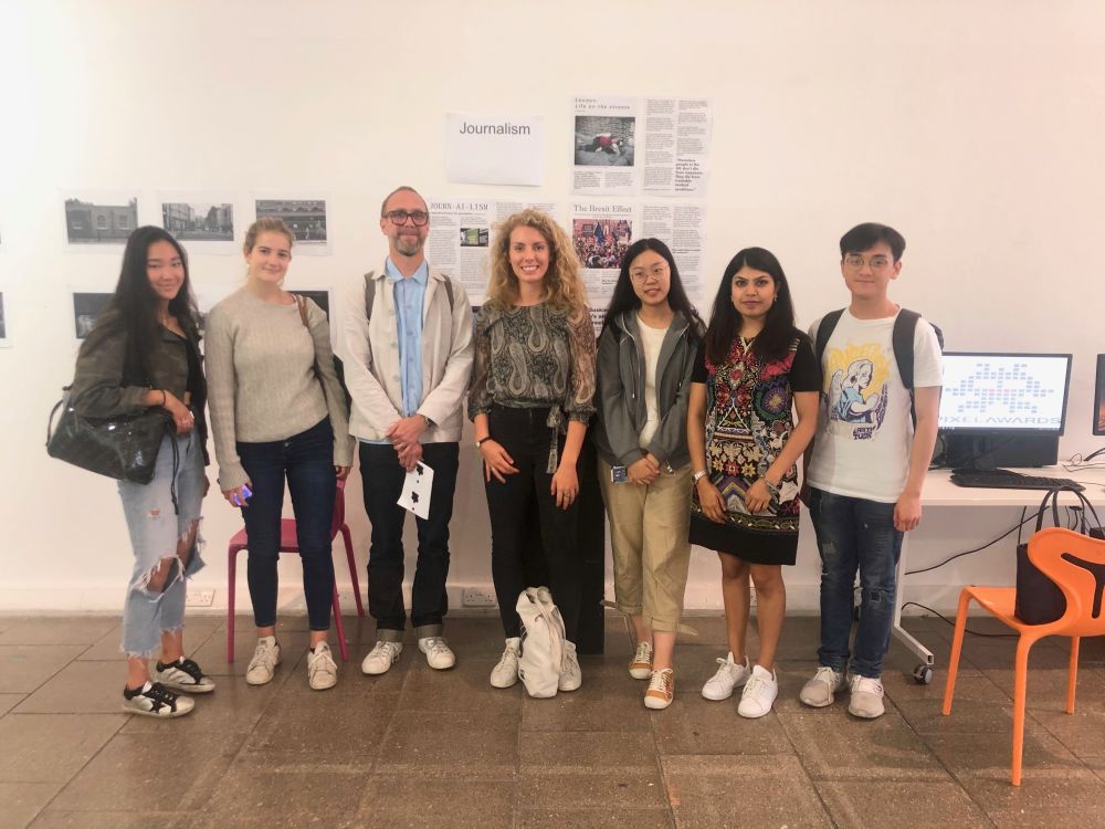 Federica with her other students and teacher with an exhibition in background