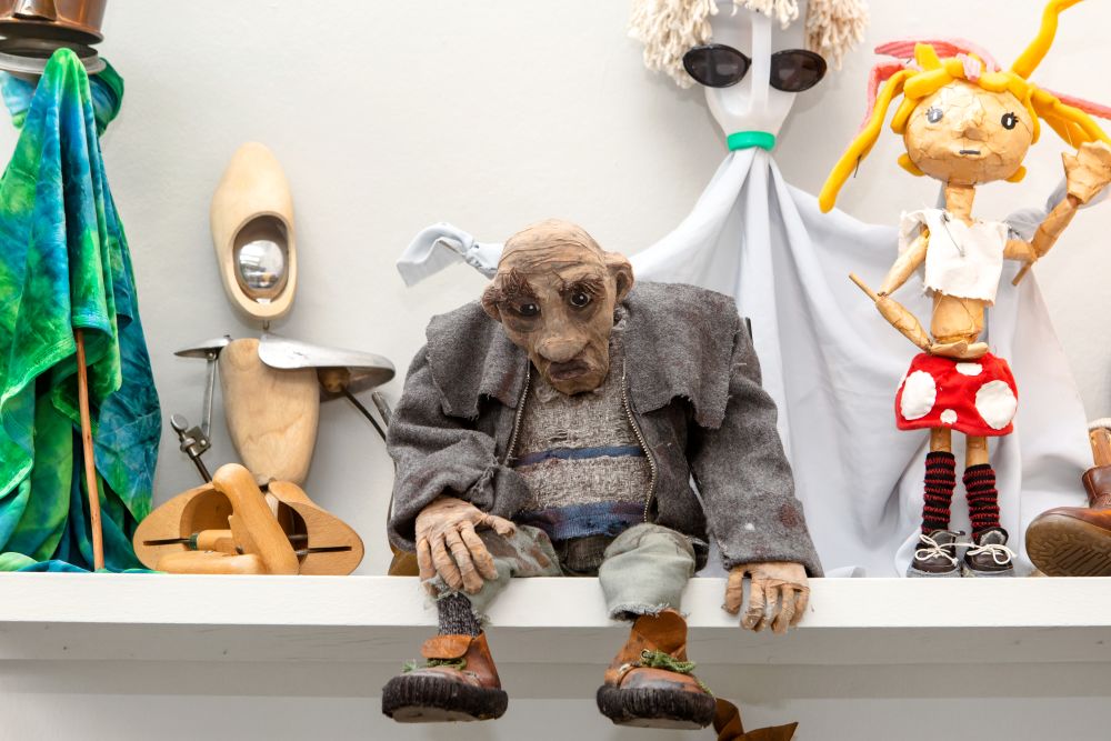A variety of puppets sitting on a shelf as part of Emergence exhibition