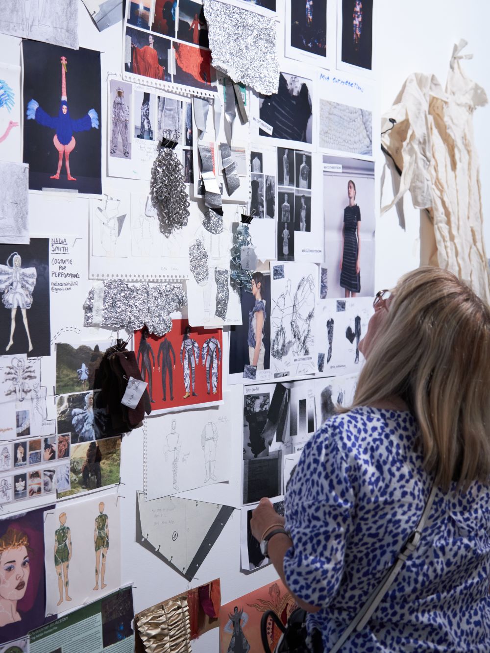 Person looking at wall of fashion designs