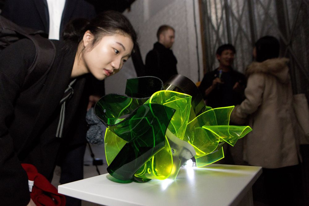 Woman looking at green perspex sculpture