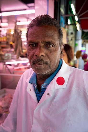 a portrait of a male in a butchers shop with red lighting