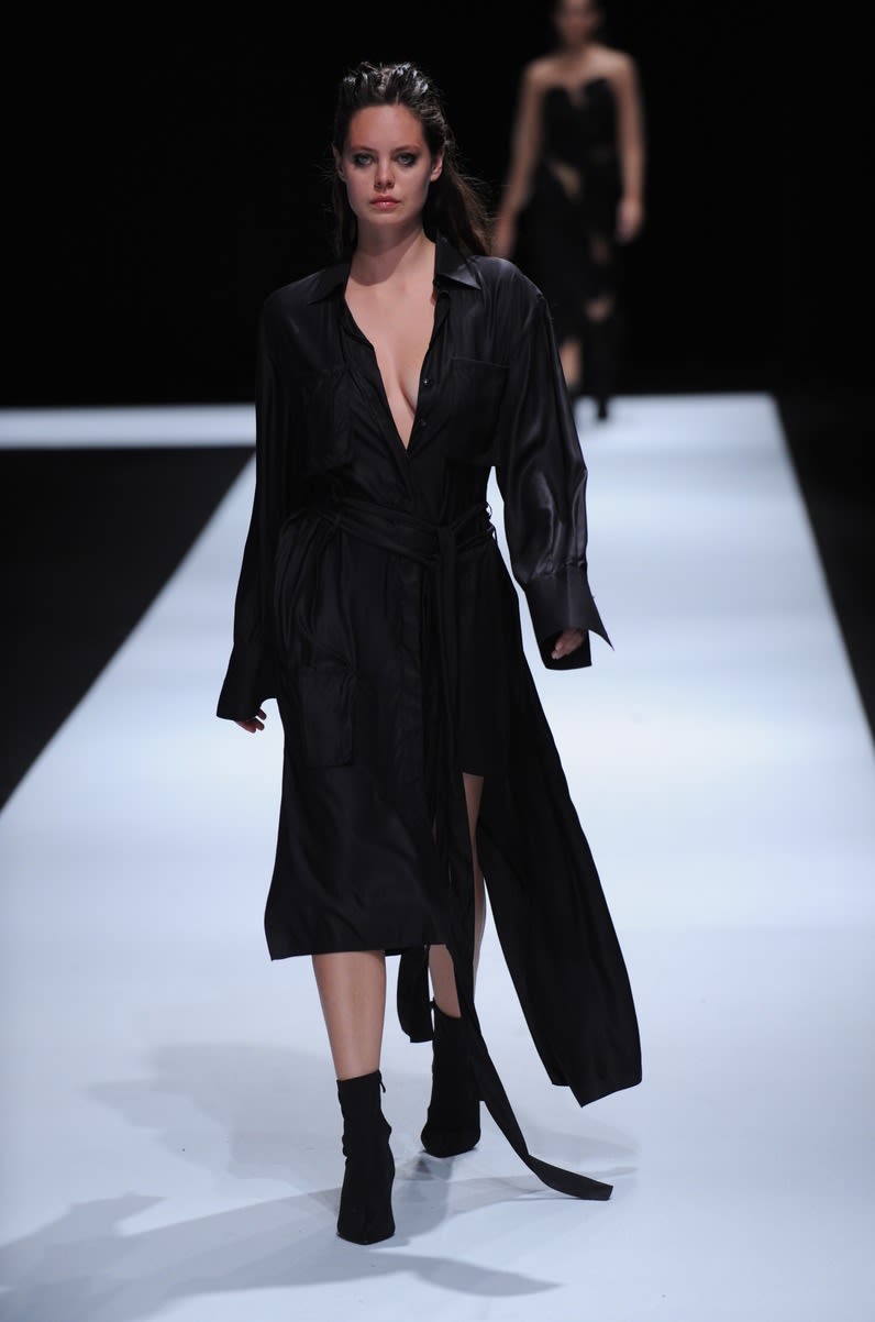 Female model wearing low cut black dress designed by Jessica Wenden