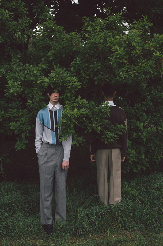 Photograph of two male models hiding under trees