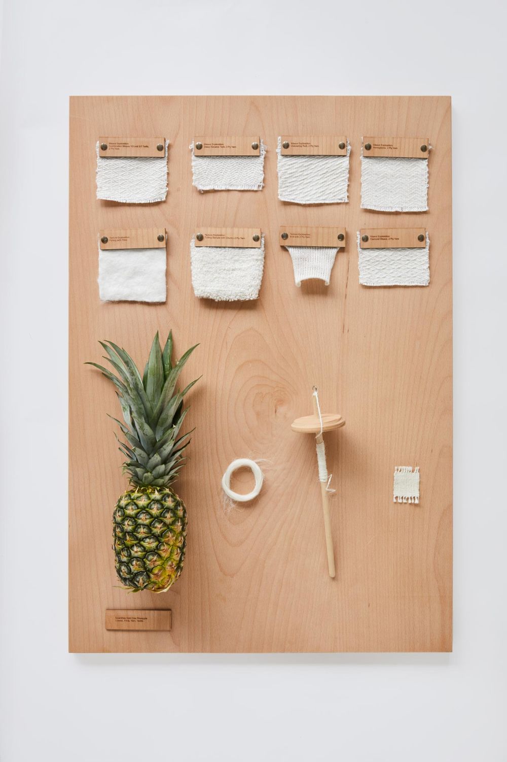 Wooden board with fabric, yarn and pineapple
