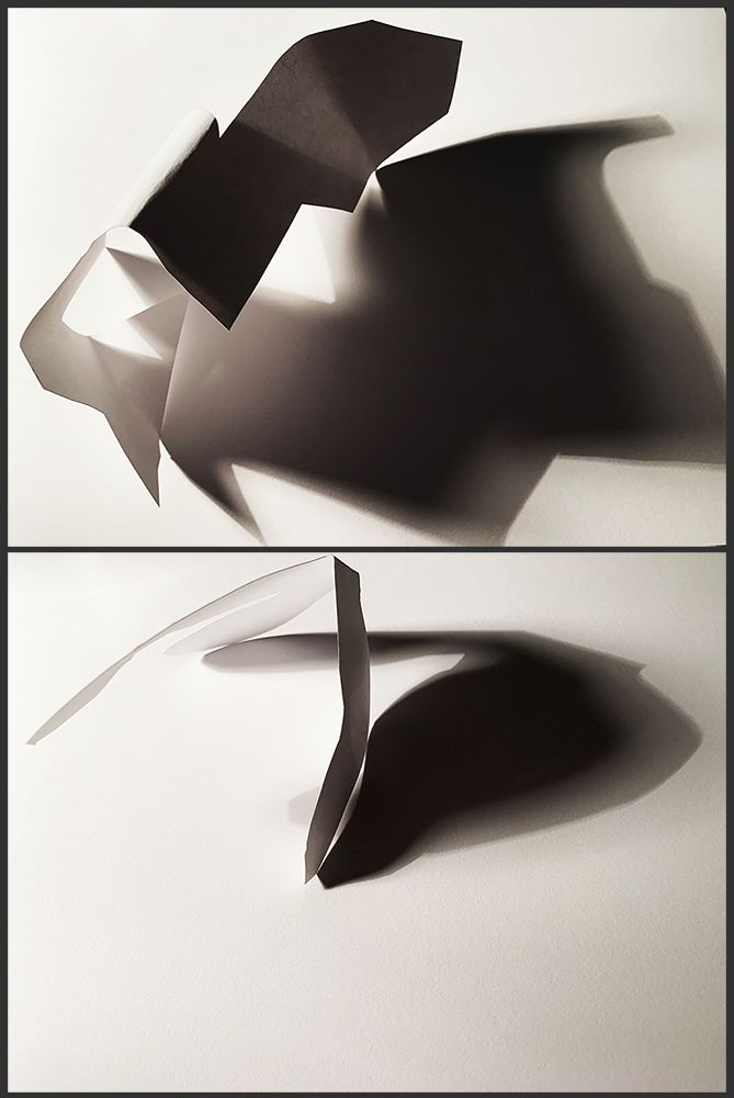 Folded and cut paper casting long shadows, spatial design work.