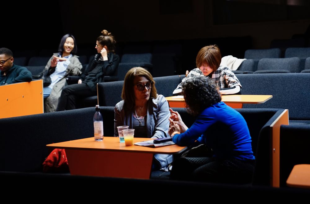 Students in dicussion in a dark lecture theatre