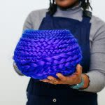 Photograph of someone holding an electric blue woven urn