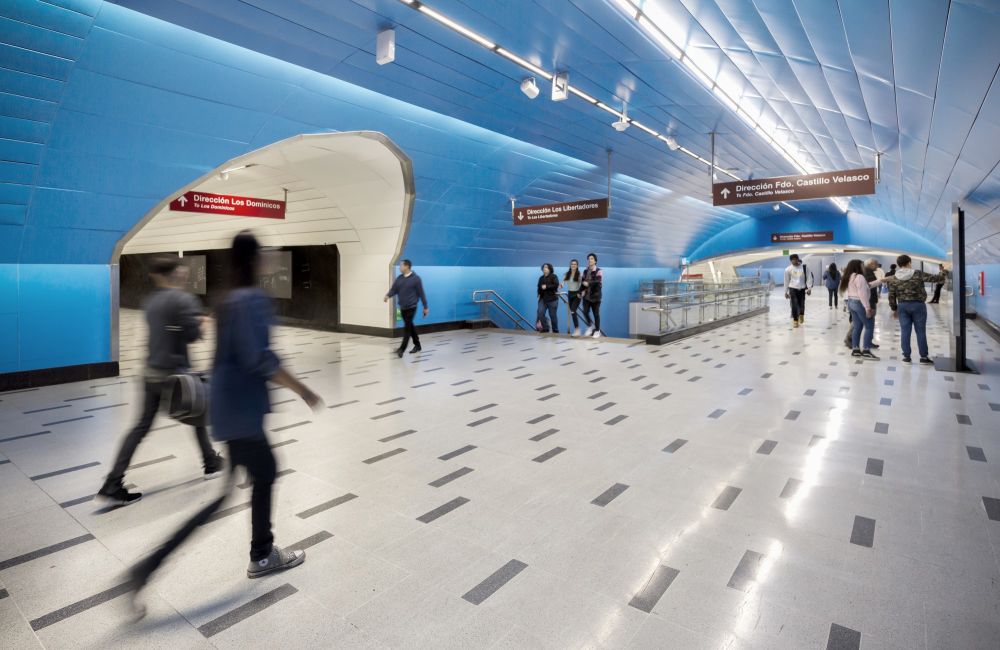 people walking within blue walkway tunnel