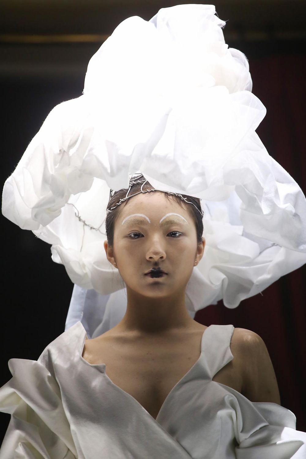 Close up of model wearing white garments and headpiece