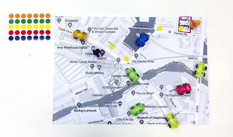 Black and white map of Camden, plotted with coloured dots and plastic cars.